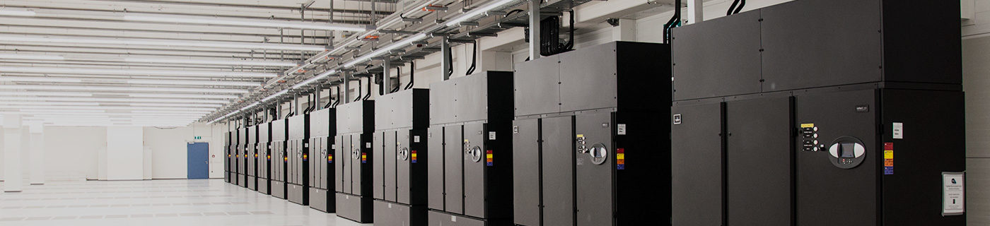 Row of data centre boxes in large white room